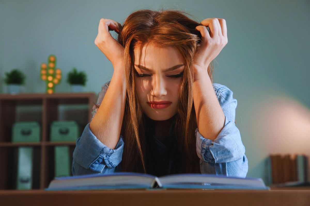 Ragazza stressata che si tiene la testa tra le mani