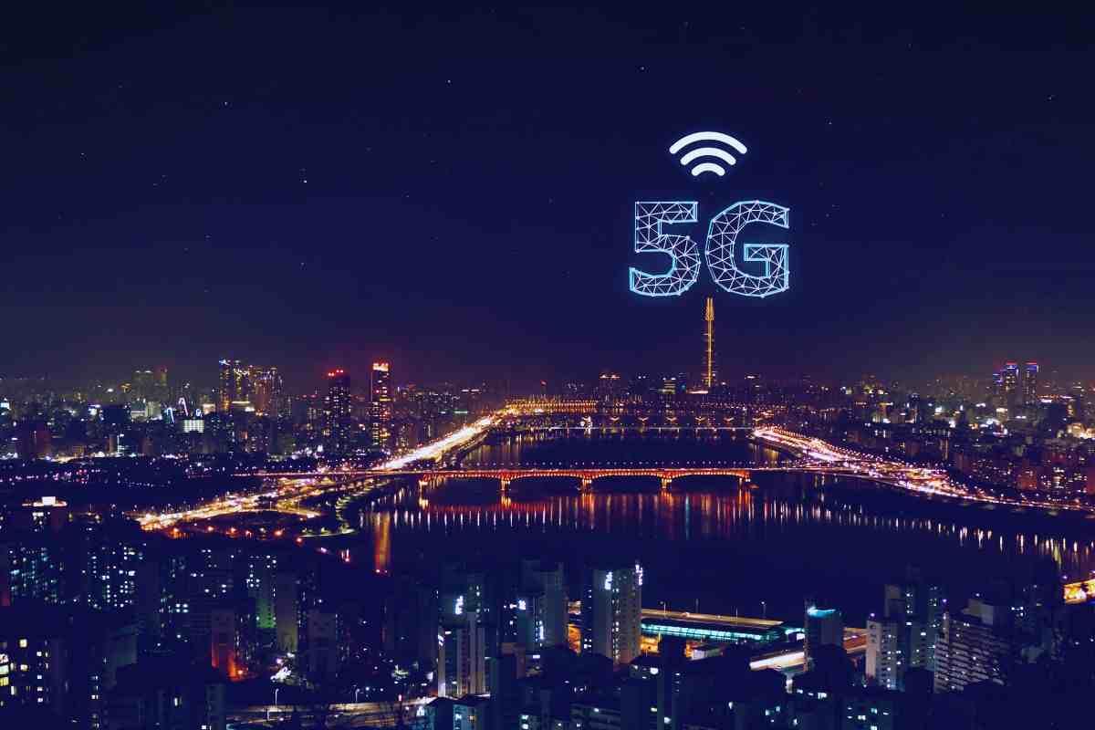 Skyline notturno di una città su cui si erge il logo 5G