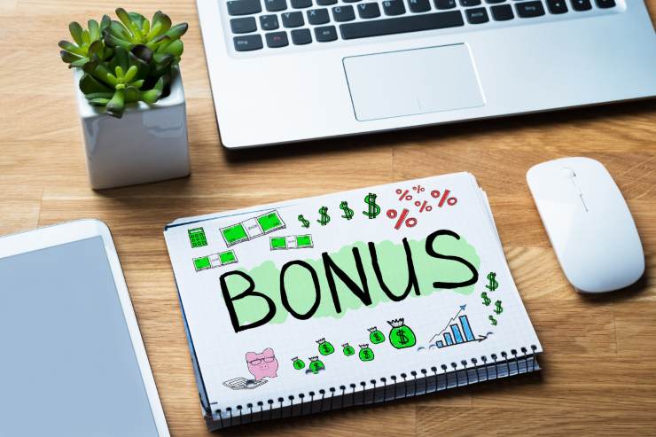 tavolo con computer piantina e agenda con la scritta bonus