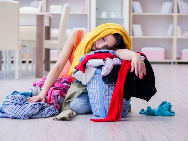 donna sommersa dai panni da lavare